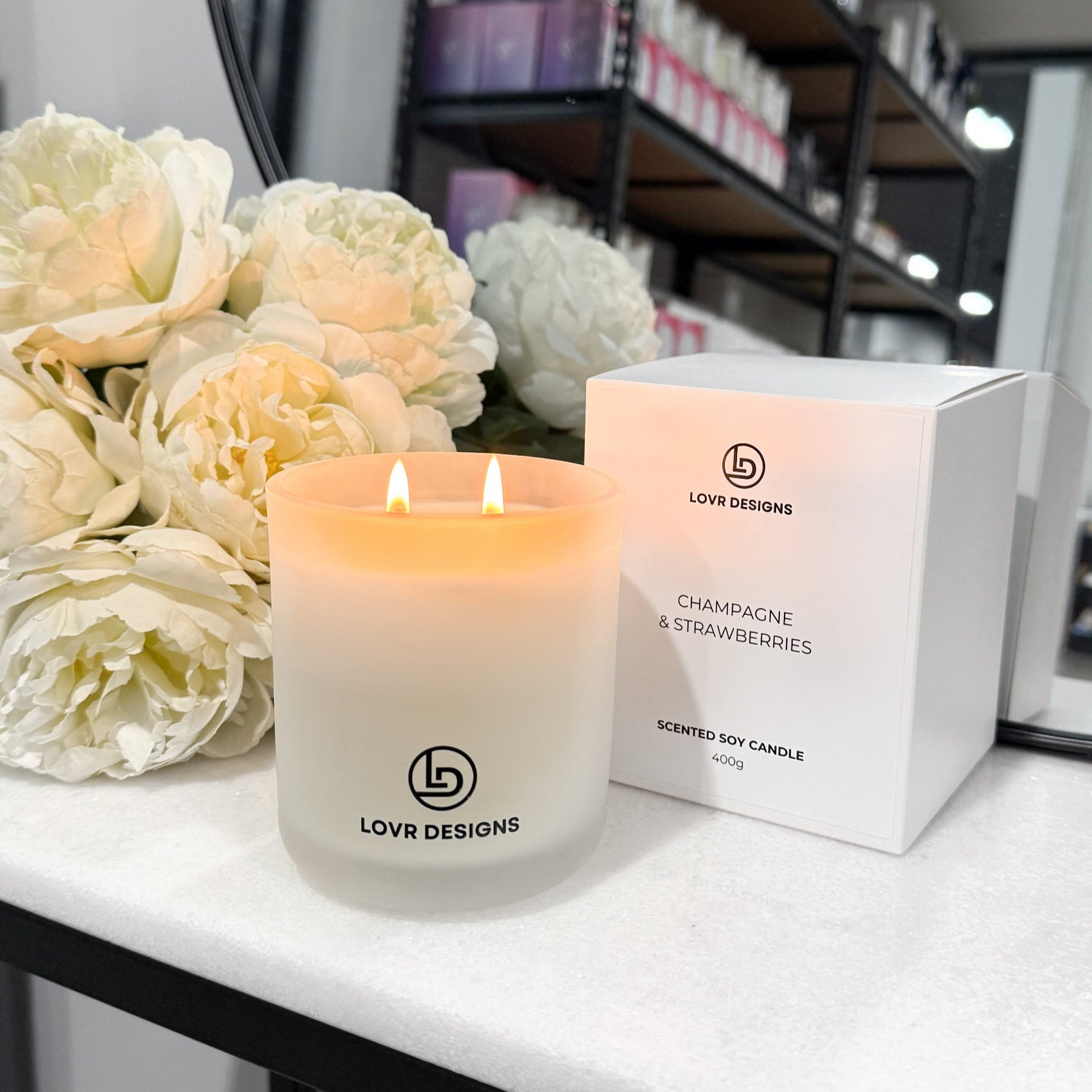 Lit candle and packaging of LOVR DESIGNS candle