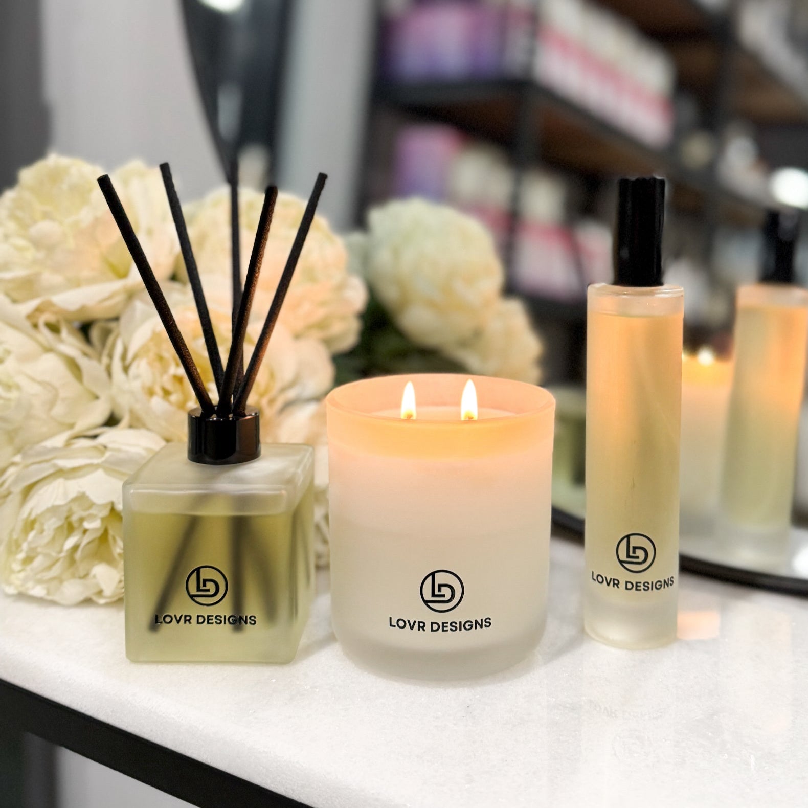 Candle, diffuser, and bottle with 'LOVR DESIGNS' branding