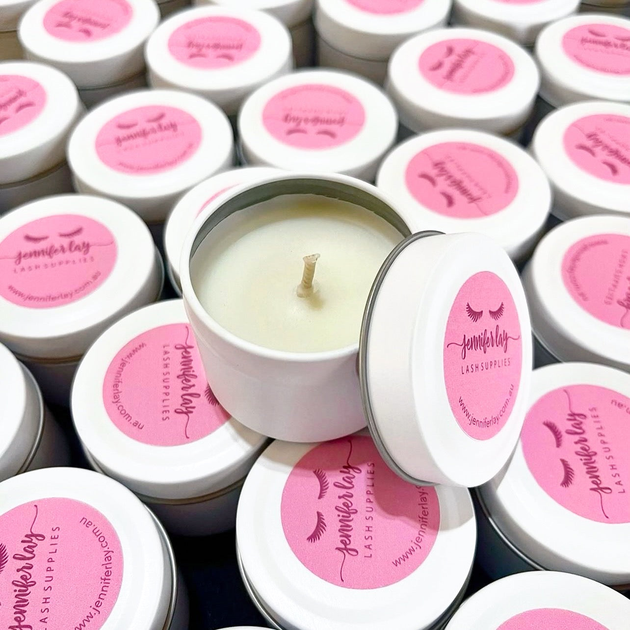 Custom branded candle tins for Jennifer Lay Lash Supplies, styled with bright pink labels for a fun and feminine look.