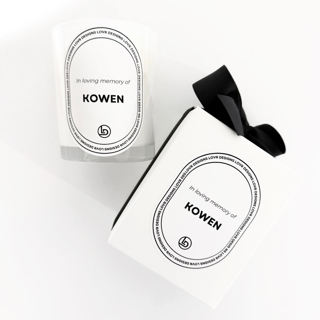 In Loving Memory Of Kowen Name scented soy candle jar next to its matching white gift box tied with a black ribbon. Hand-poured in Melbourne, this 200 g memorial candle features premium soy wax and a lead-free cotton wick for up to 35 hours of burn time