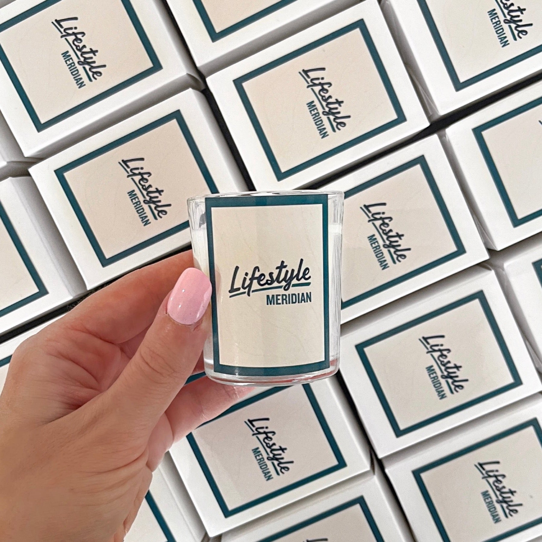 60g custom branded soy candle for Lifestyle Meridian Clyde North, with teal and white label, perfect for real estate gifting.