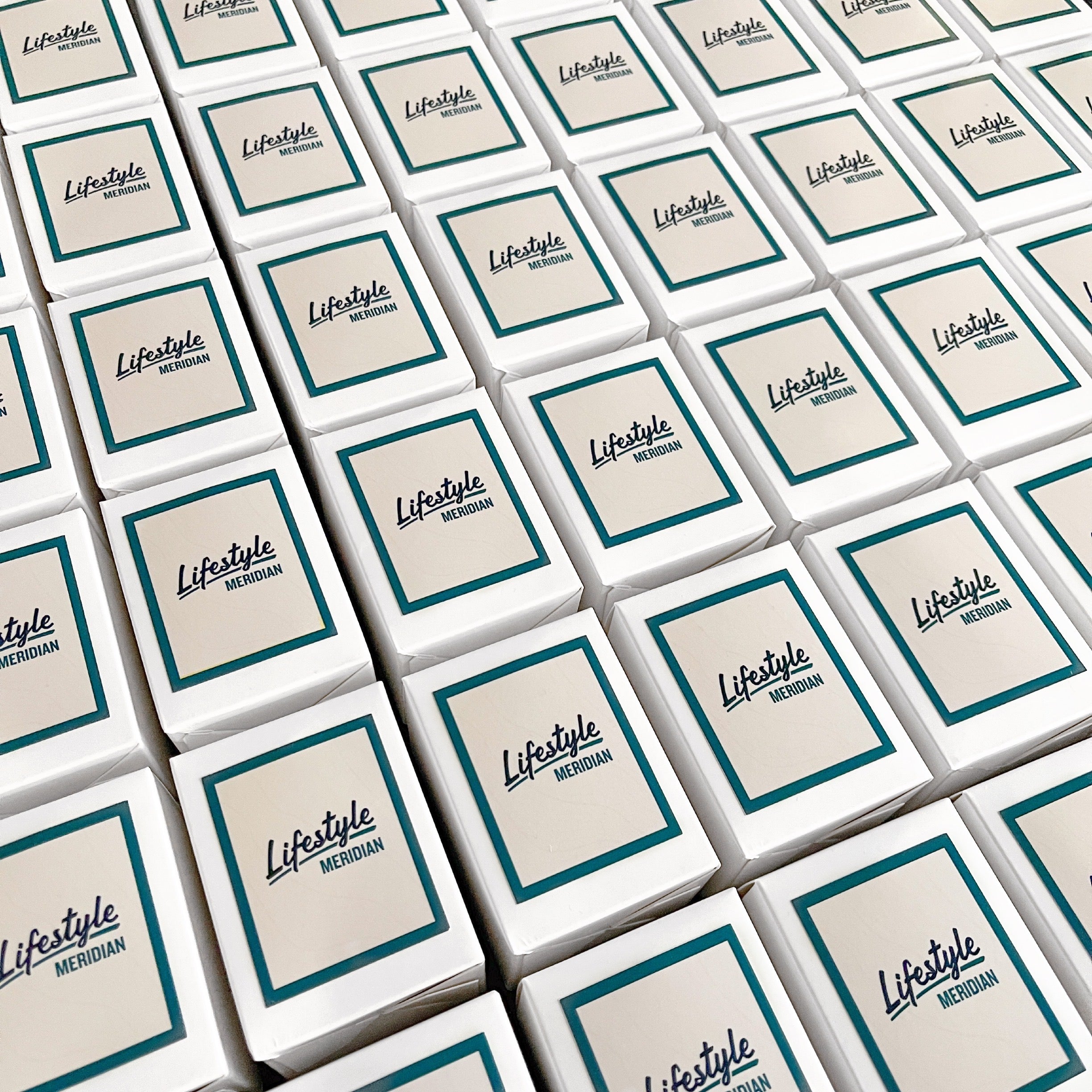 Grid of custom branded 60g candles for Lifestyle Meridian Clyde North. Teal-bordered label on white gift boxes, perfect for real estate settlement gifts.