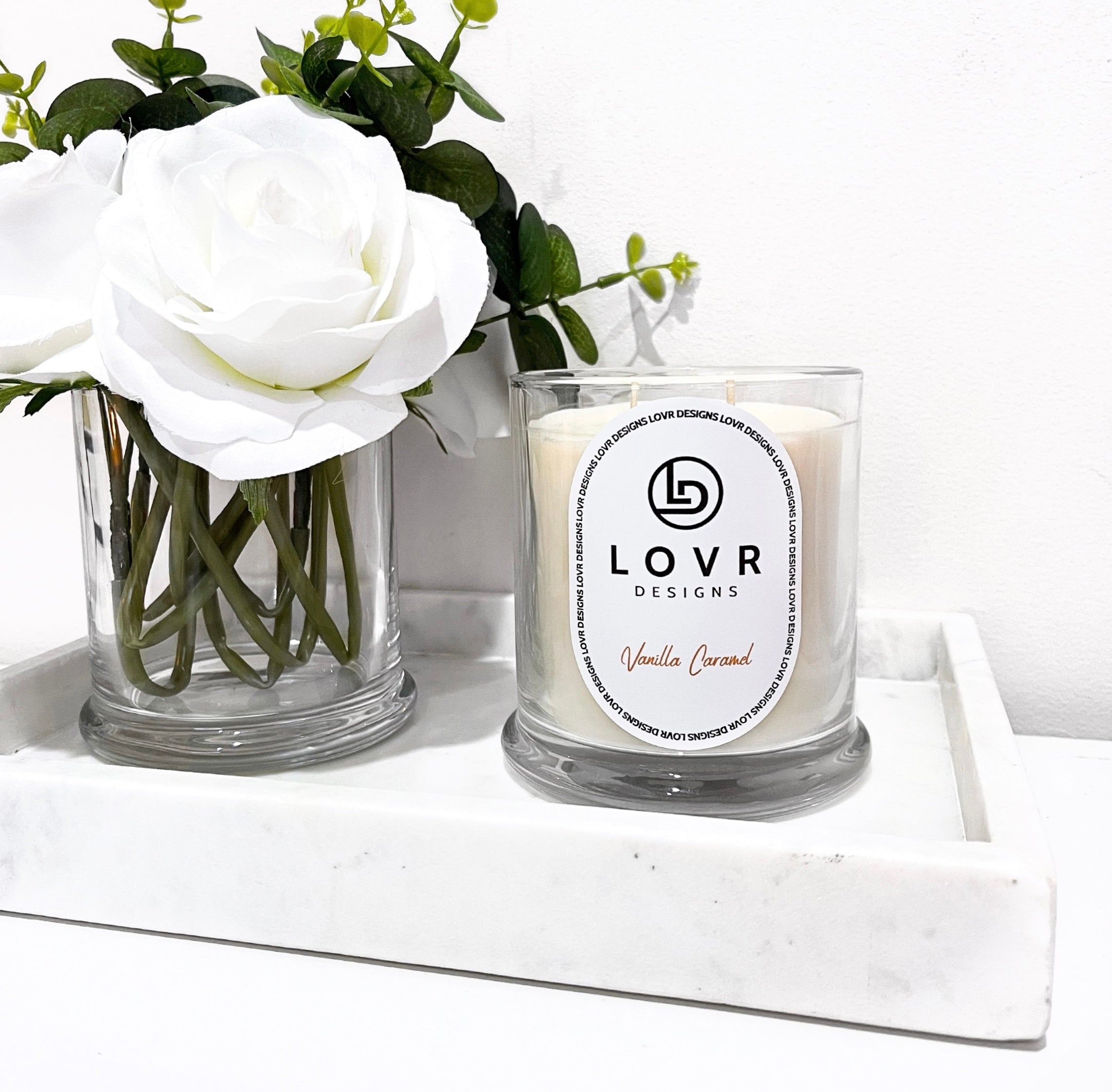 Vanilla Caramel scented soy candle by Lovr Designs styled on a marble tray with white flowers – 400g Signature Collection.