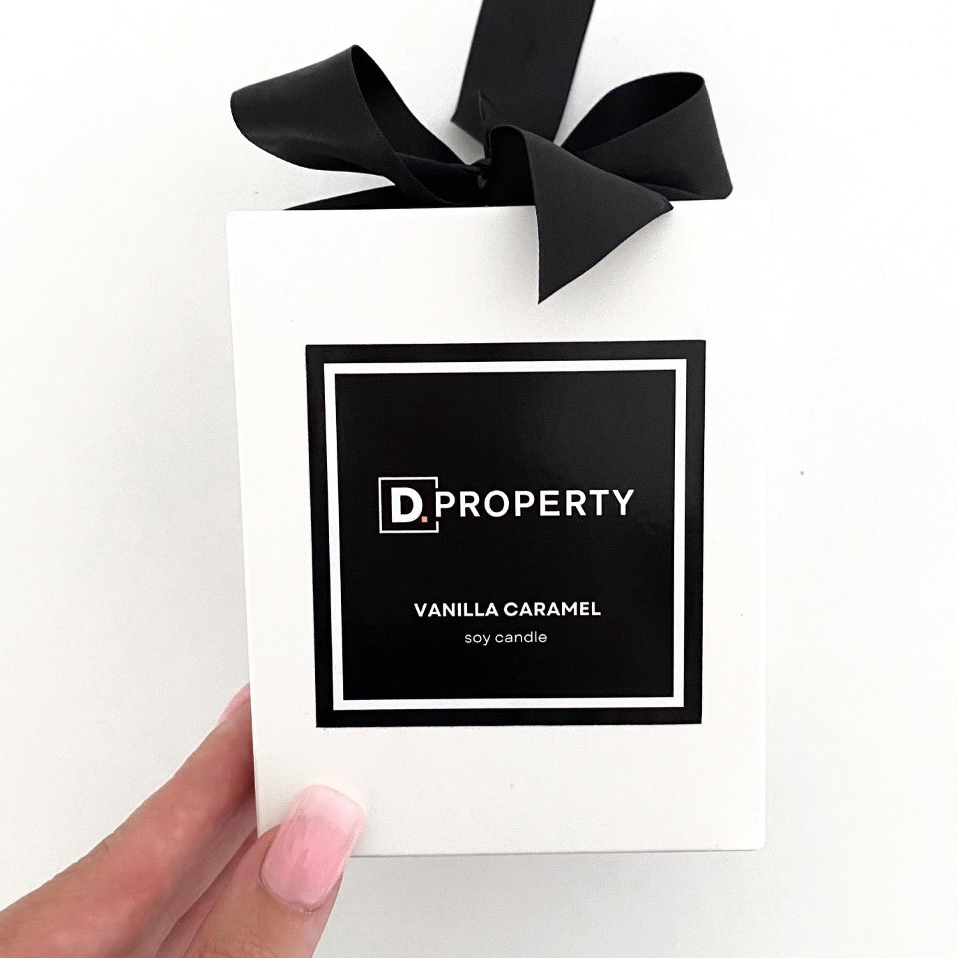 Large 300g custom branded soy candle for D. Property Malvern featuring a black square label with Vanilla Caramel fragrance.