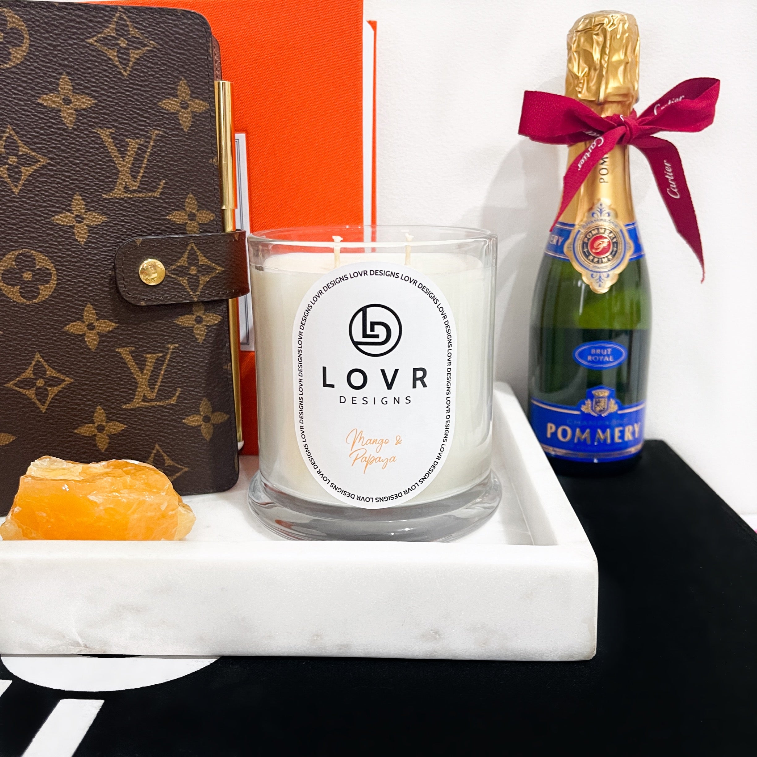 Mango & Papaya soy candle styled with champagne bottle and luxury accessories – Lovr Designs