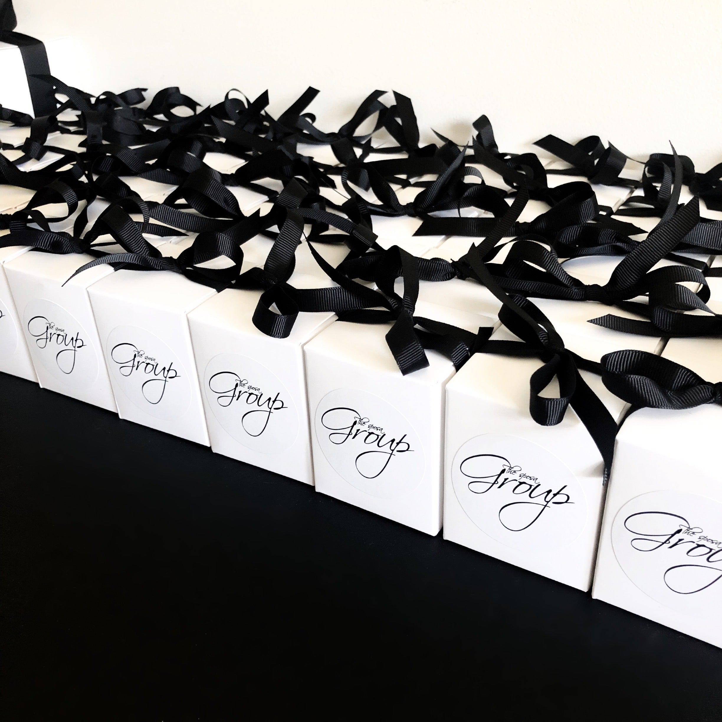Custom branded 60g wedding event favour candles for The Sposa Group, featuring black ribbon and script logo labels. Perfect for luxury bridal events and client gifting.