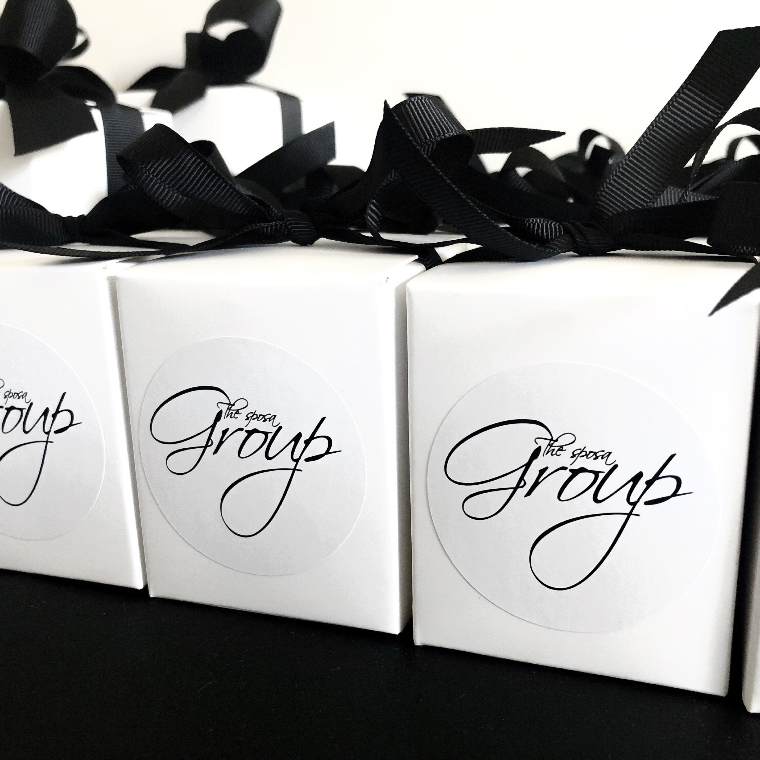 60g custom branded wedding favour candles for The Sposa Group. Clean white packaging with elegant script labels and black ribbon for formal events.